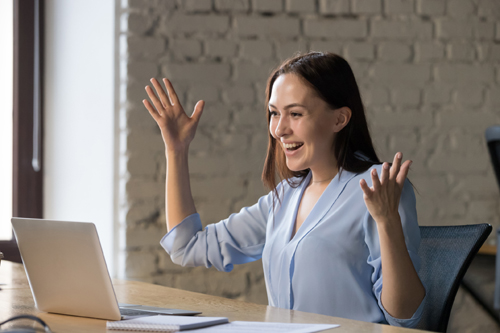 Businesswoman using laptop, receiving good news